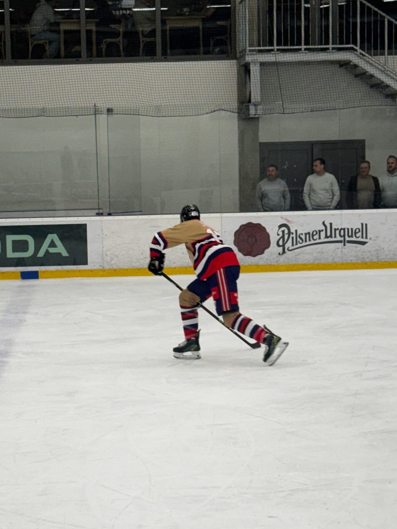 Rusty Mitts skater unloading a shot in front of Pilsner Urquell boards